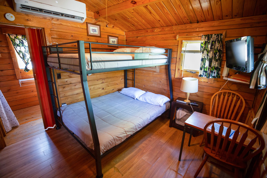 rustic johnson city tx cabins bedroom with comfortable bunk beds and wooden interiors, Miller Creek RV Park