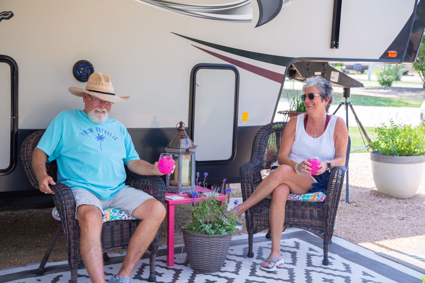 retired couple relaxing at a spacious RV site in a retirement RV park near San Antonio, TX, enjoying a sunny day outdoors