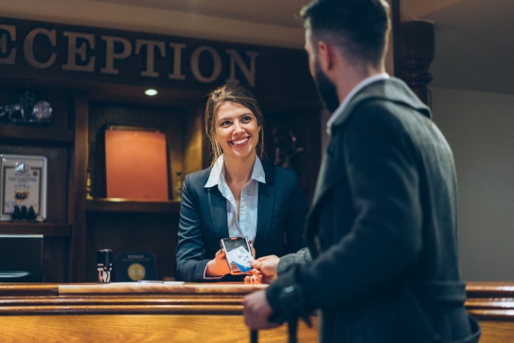 smiling receptionist attending to hotel guest