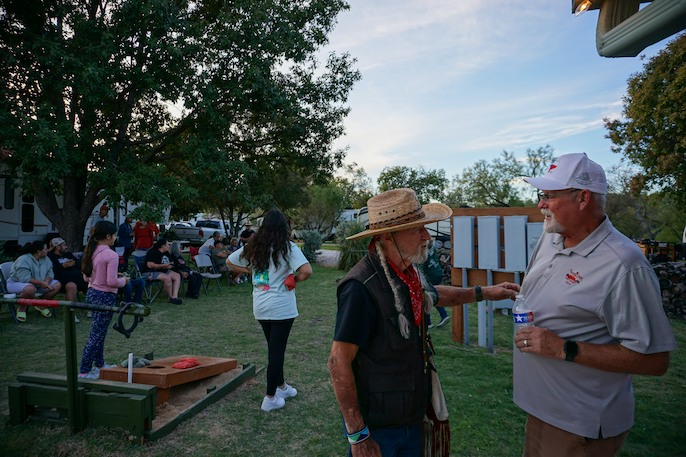 Lively outdoor gathering at an RV park with people socializing and enjoying activities