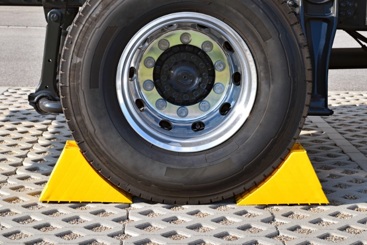 RV tire secured with bright yellow wheel chocks for stability