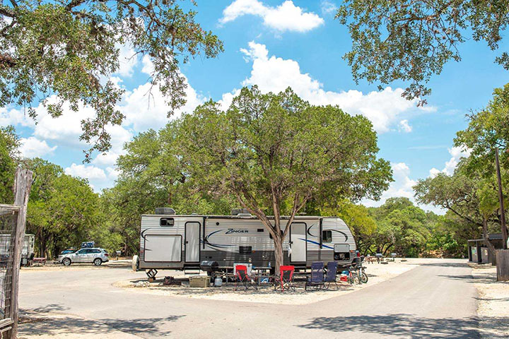 Spacious RV campsite at Yogi Bear’s Jellystone Park Camp-Resort with outdoor seating and shaded trees