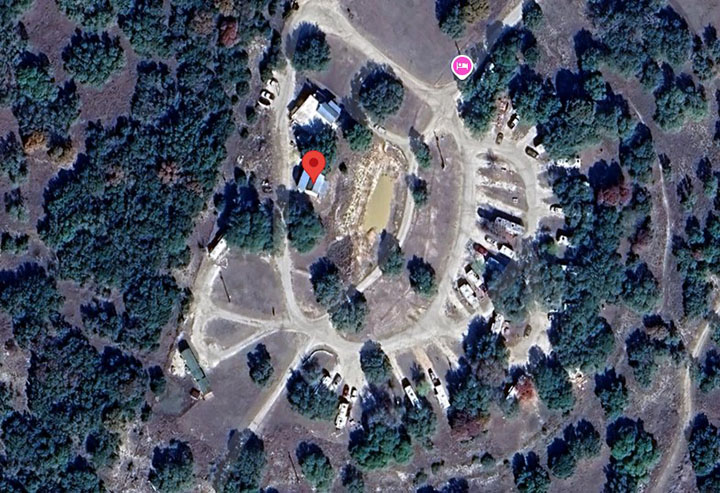 Aerial view of River Oaks Riverfront RV Resort showing RV sites surrounded by trees