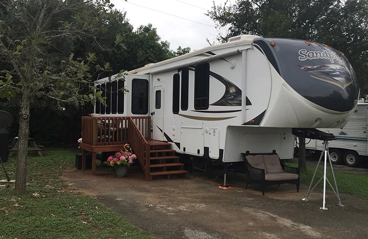 Spacious RV campsite at Wagon Wheel RV Park with a wooden deck and greenery surrounding the area