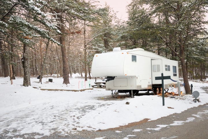 Winterized RV setup for cold-weather camping with insulation and snow gear