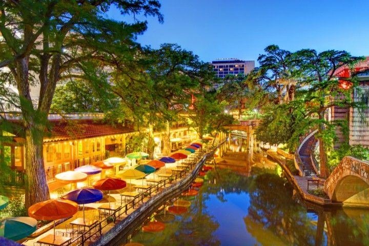 Evening view of San Antonio River Walk lined with colorful umbrellas and glowing lights