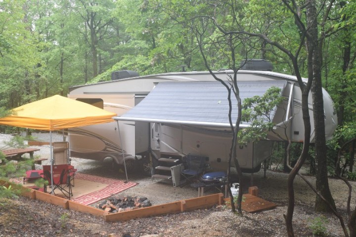 Sustainable RV camping setup with an outdoor canopy and fire pit