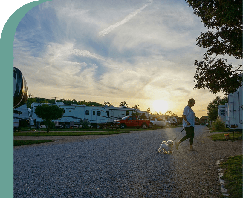 Guest walking a small dog through an RV park near Blanco, Texas