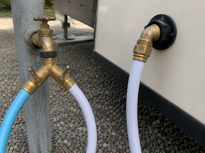 Brass 45-degree hose elbow and Y-splitter connected to an RV park water spigot