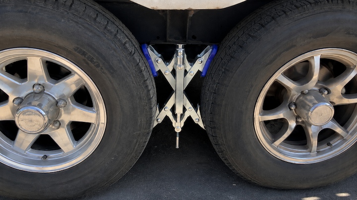 X-chock wheel stabilizer secured tightly between dual travel trailer tires