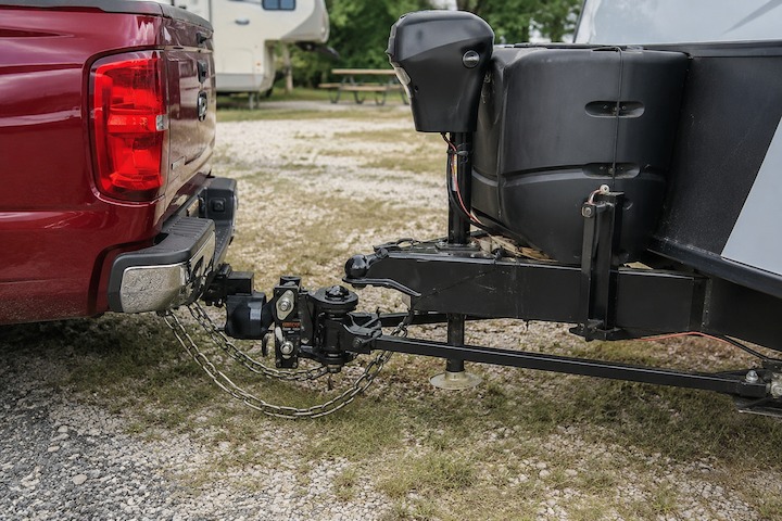 Weight distribution hitch with sway control connecting a pickup truck to a travel trailer at an RV campsite