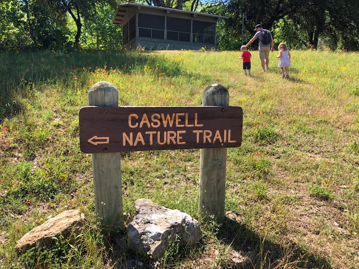 Father and two children exploring the Caswell Nature Trail on a sunny day