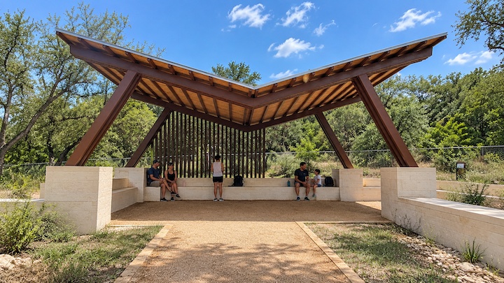 Open-air pavilion with a covered roof along a trail at Barton Creek Greenbelt